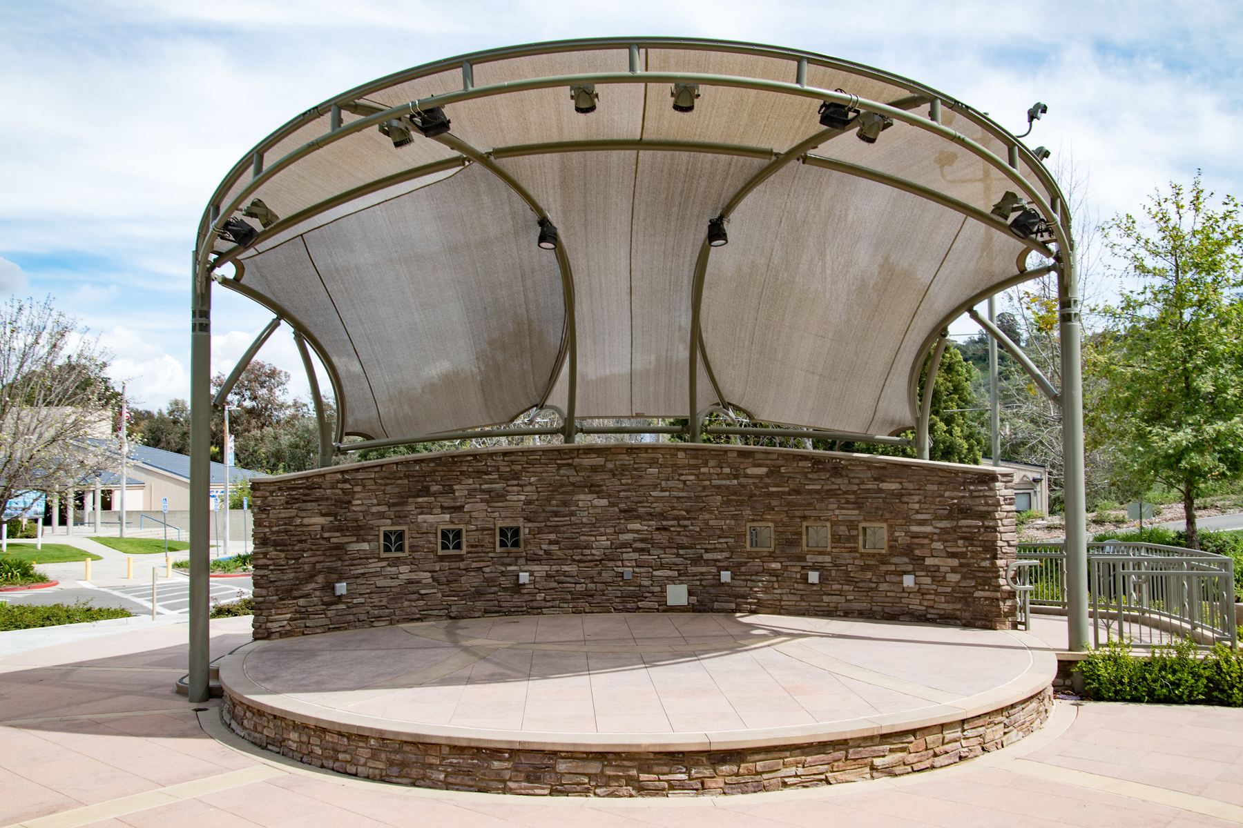 outdoor venue stage with shade and stone accent backdrop