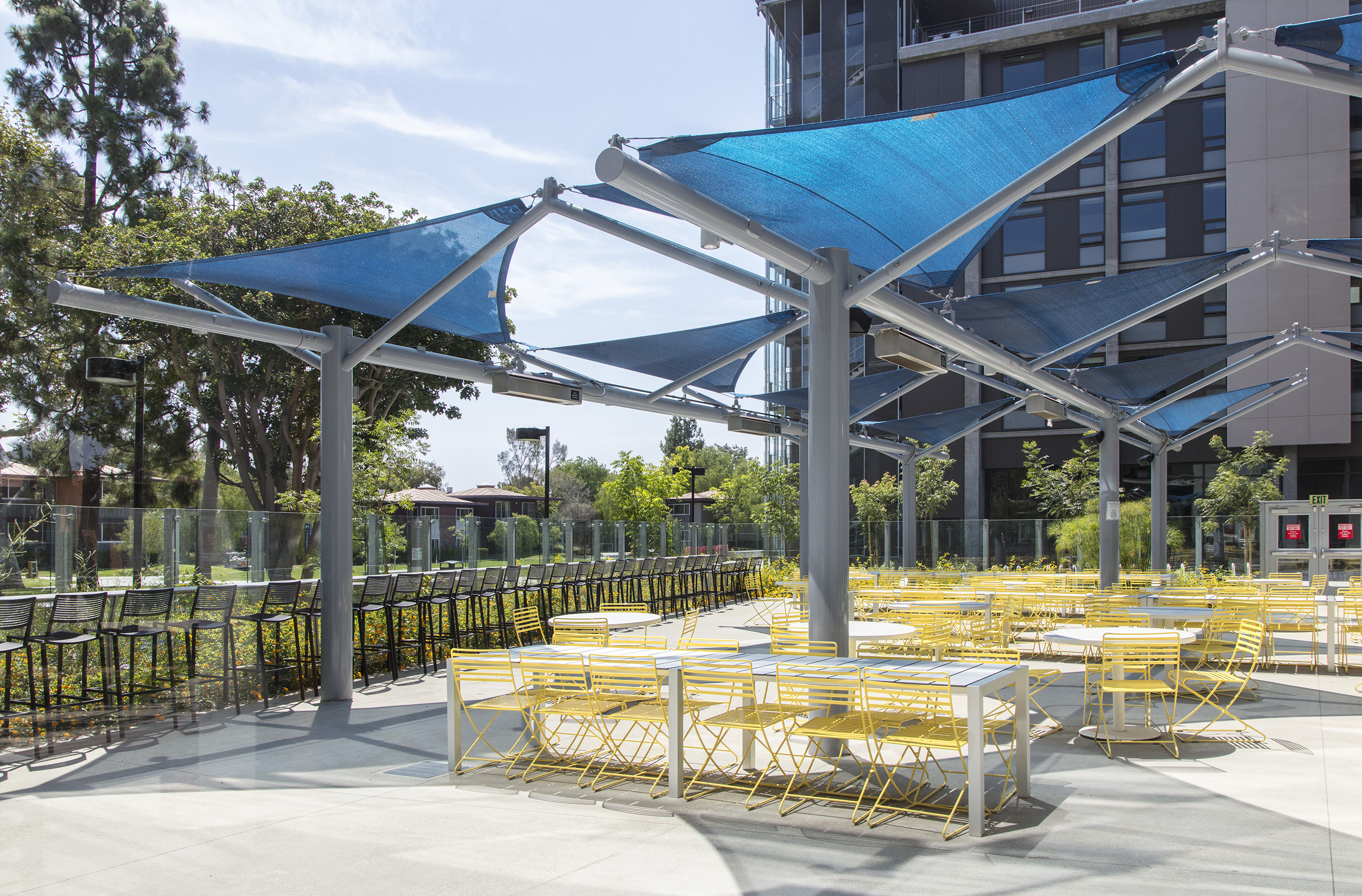 blue triangle sun shade covering outdoor tables