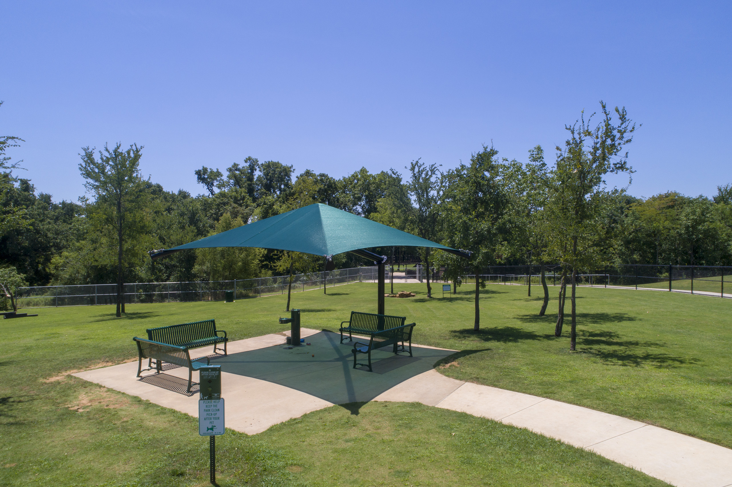 Park seating area shaded by green usa shade