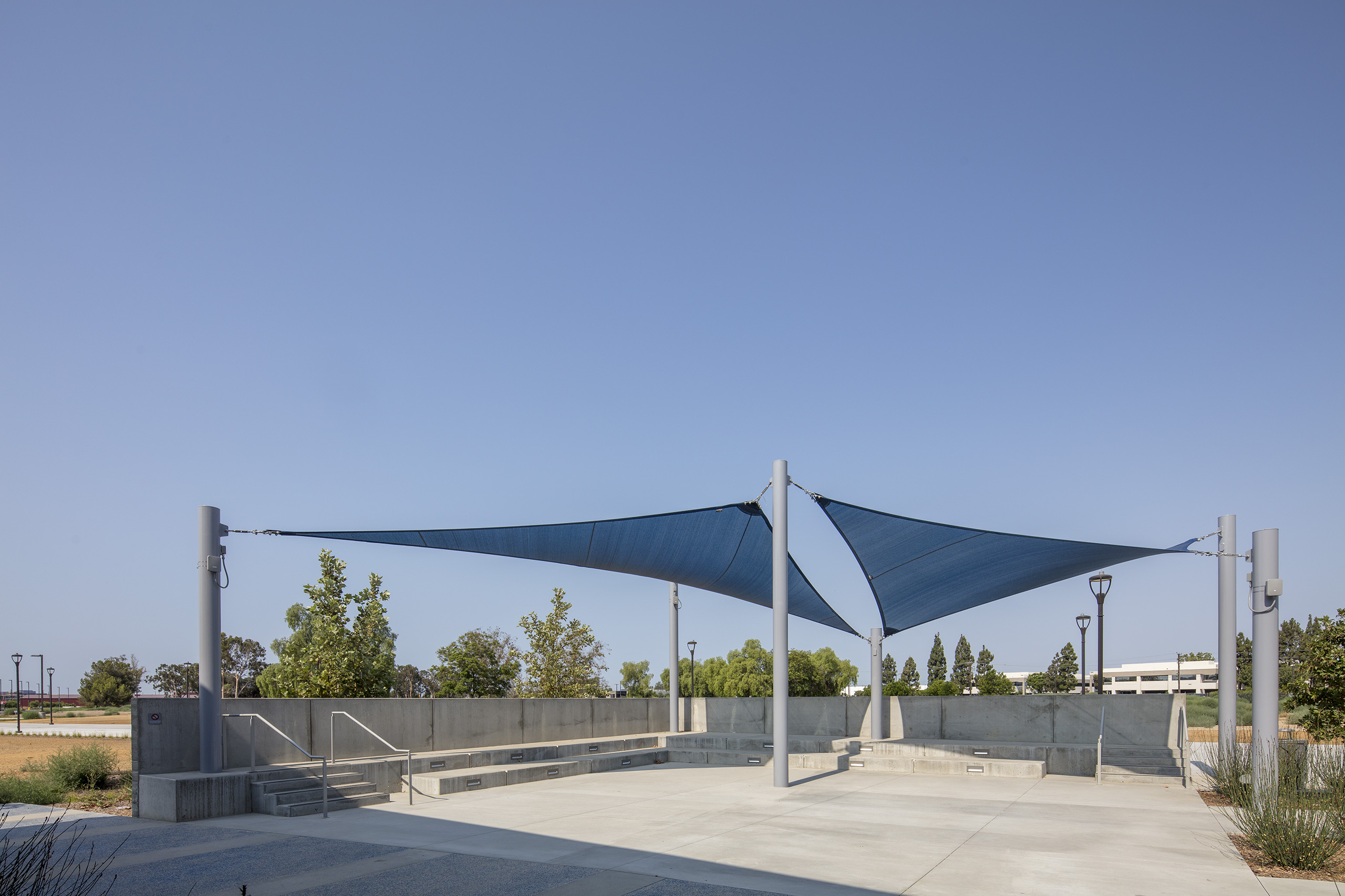 blue triangle shades covering concrete patio