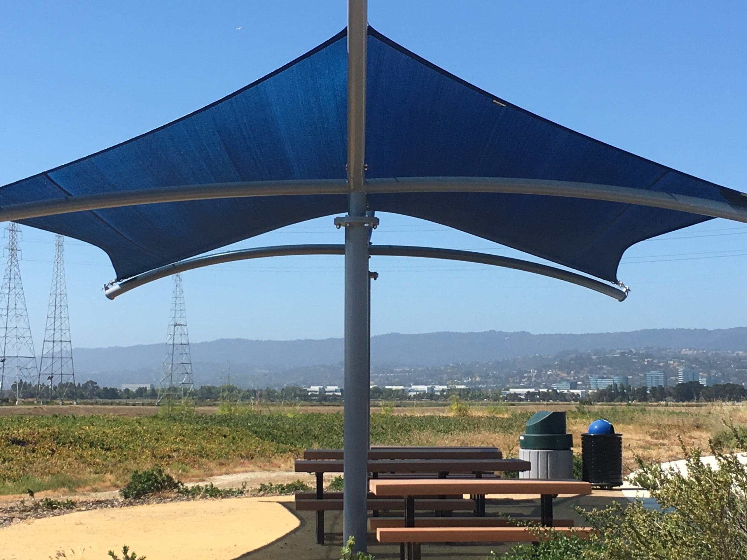 picnic tables under a blue usa shade