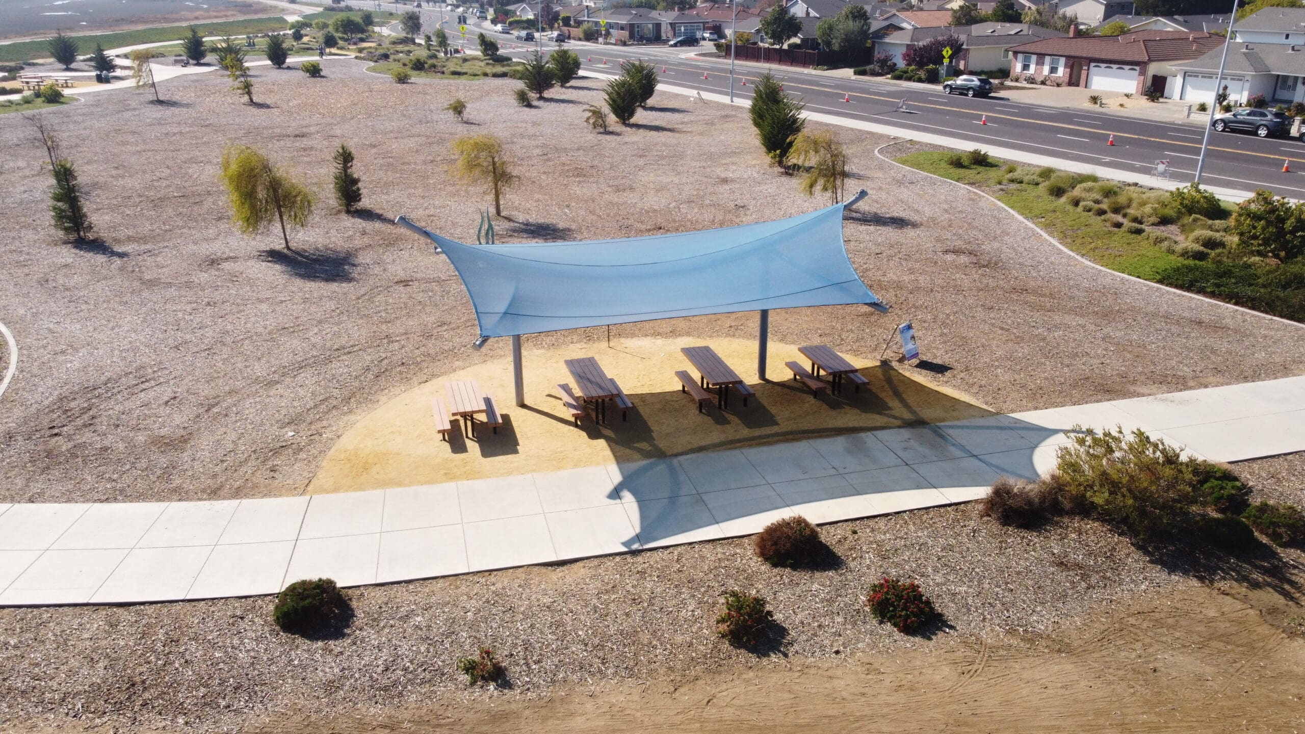 outdoor picnic tables covered by blue sun shade