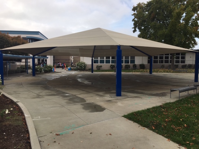 large sun shade structure in front of school