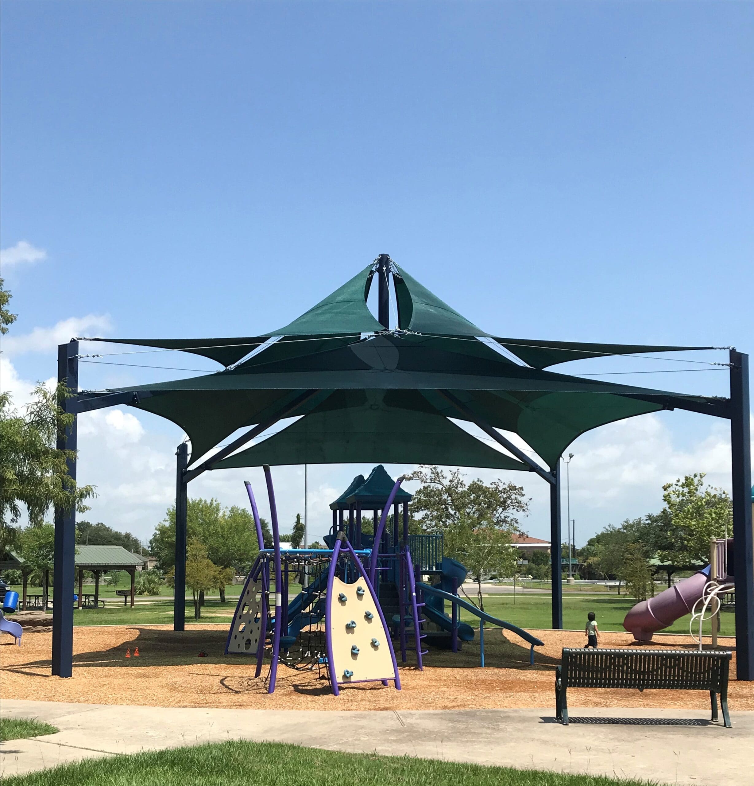 purple playground set up outside under usa shade