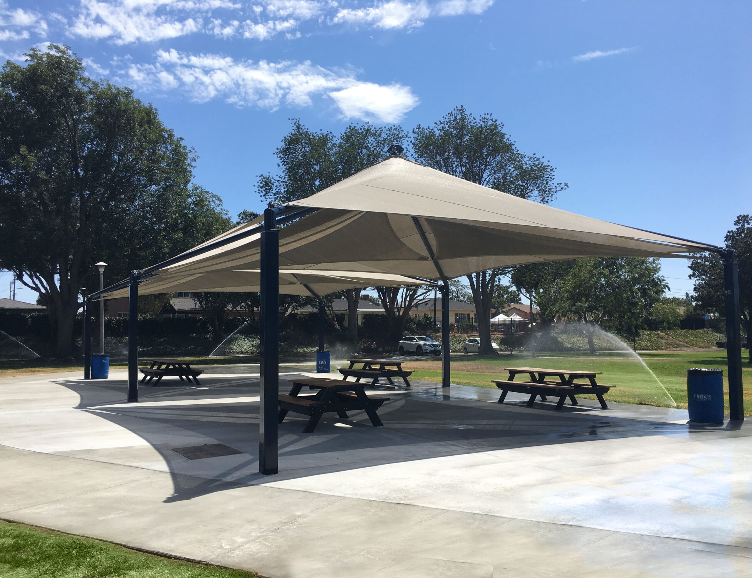 picnic tables covered by tan usa shade
