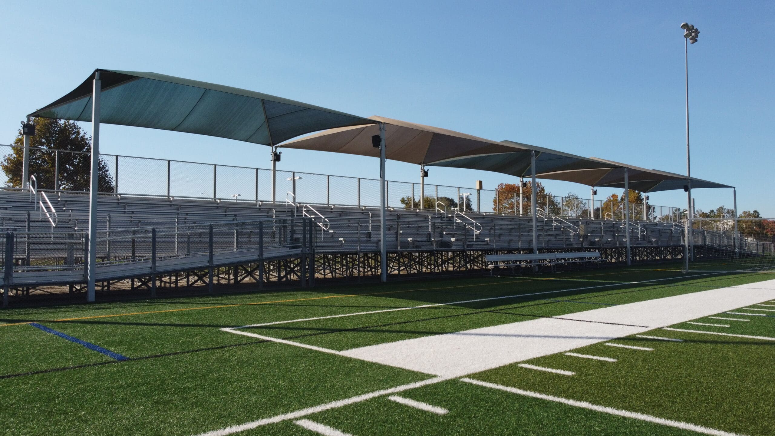 USA SHADE fabric shade structure over sports bleachers
