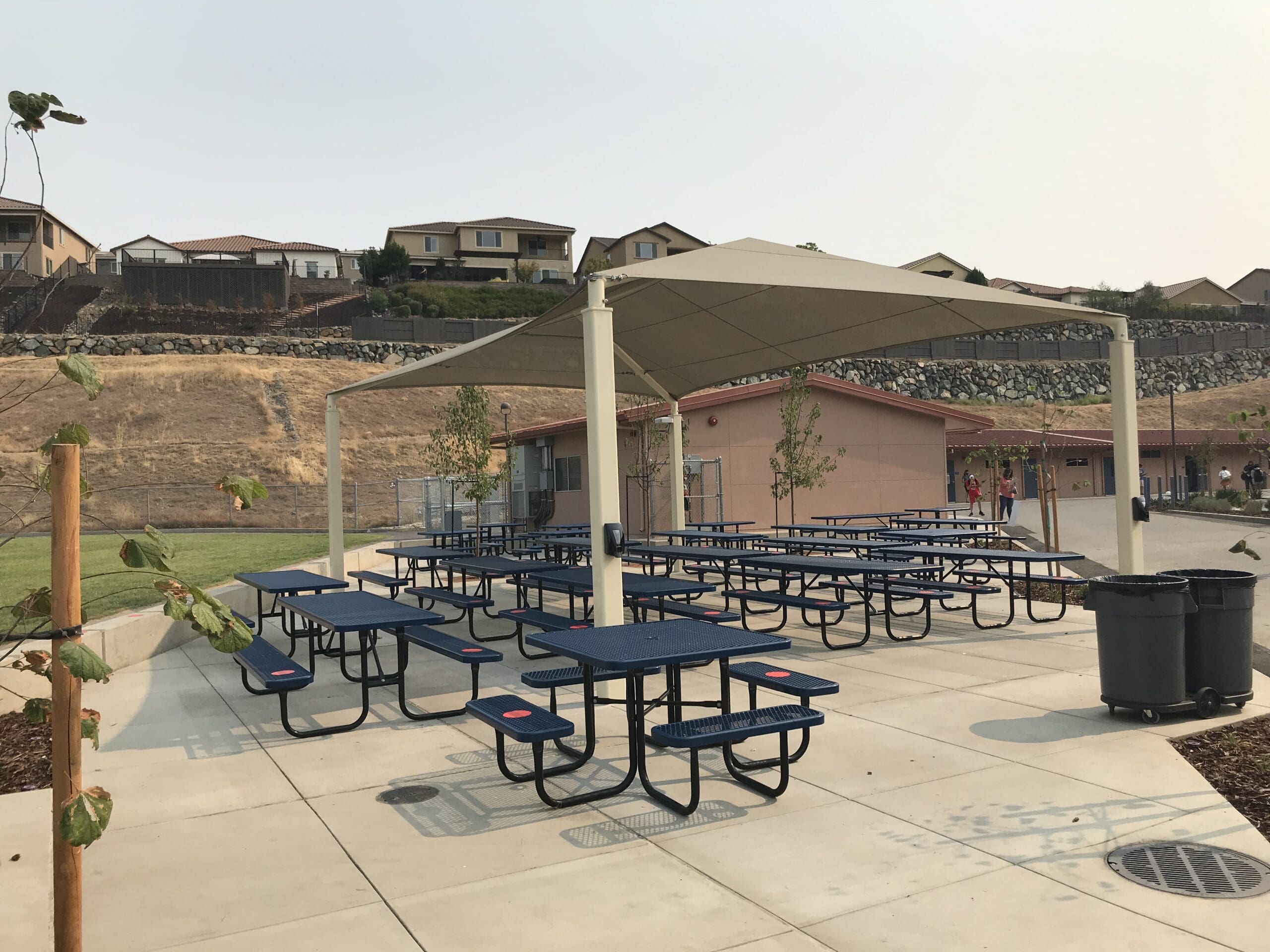 multiple picnic tables covered by usa shade