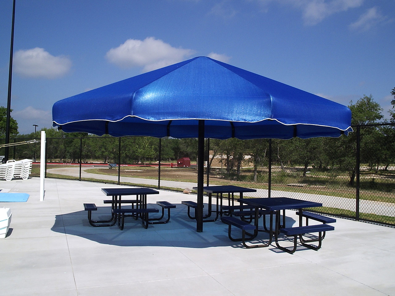 blue umbrella shade covering picnic tables