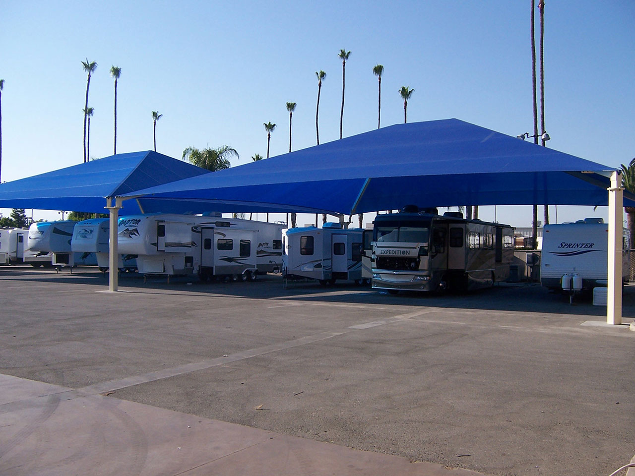 mulitple recreational vehicles set up under usa shades