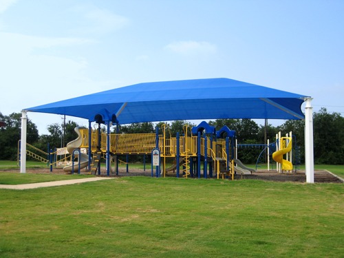 large sun shade structure over yellow playground