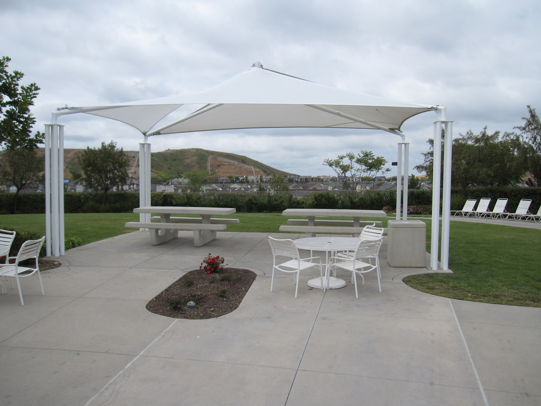 multiple outdoor dining tables underneath usa shade