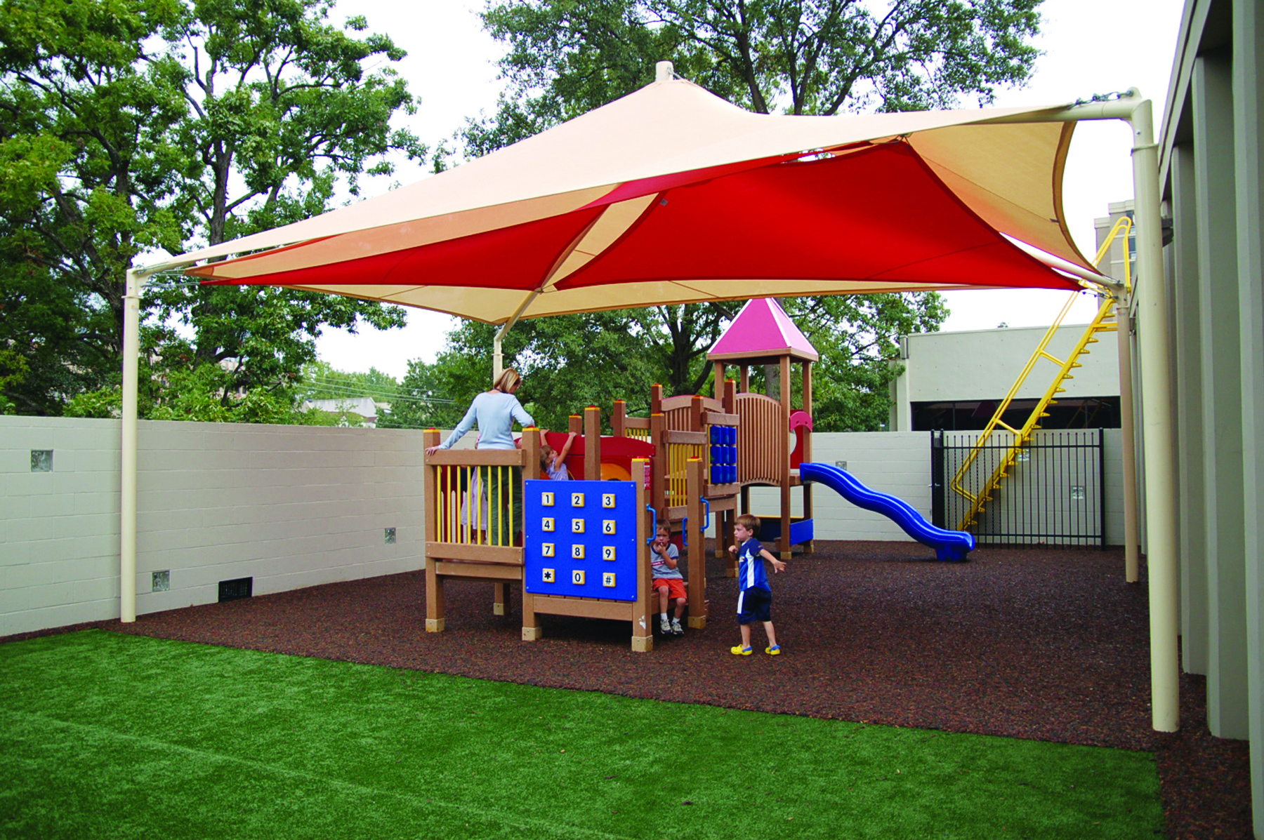 young children playing on playground under usa shade