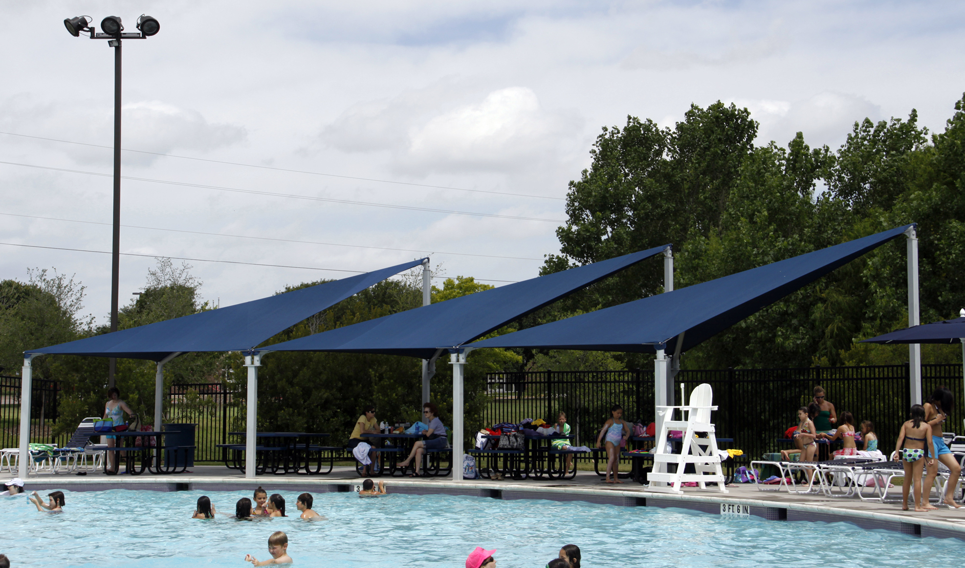 usa shades covering outdoor picnic tables at pool