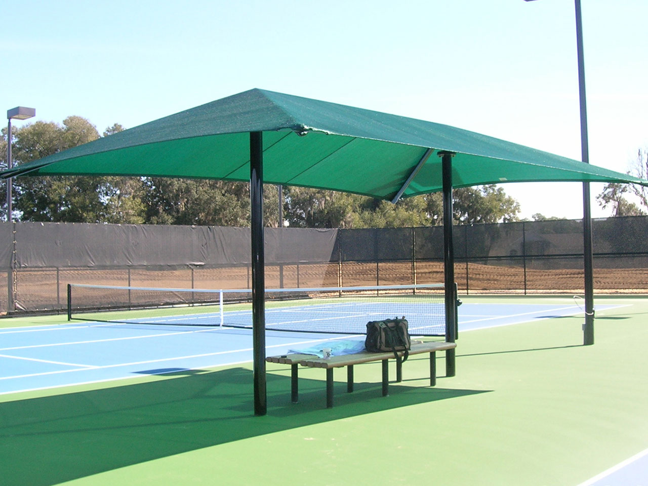 shaded bench next to tennis court