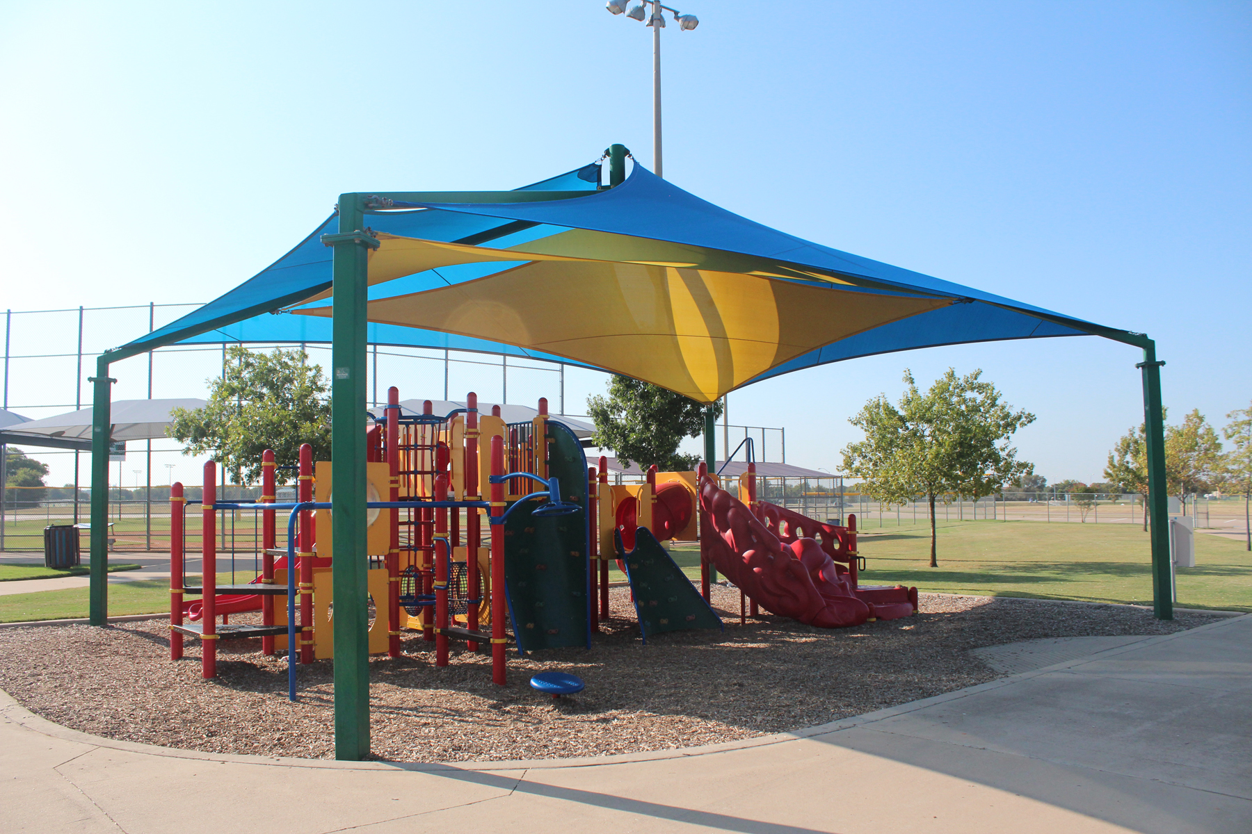 red playground covered by 4 post usa shade